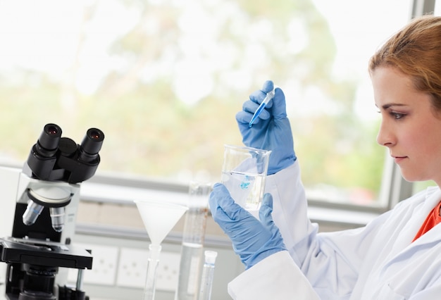 Science student dropping liquid in a beaker