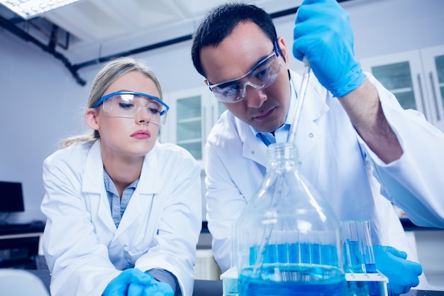 Science students using pipette to fill beaker