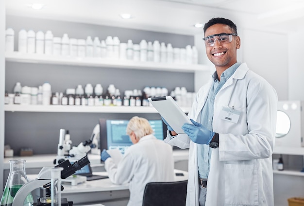 Science tablet and portrait of a male scientist doing research with technology in a medical laboratory Happy smile and man chemist or biologist working on a mobile device in a pharmaceutical lab