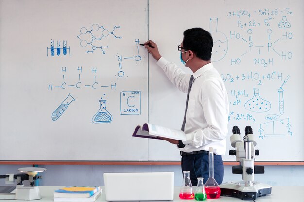 Science teacher teaching in the classroom with wearing face mask