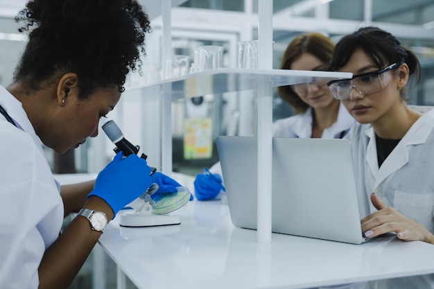 Science technology chemist developing concept female researcher medical scientist or doctor or student is looking in a microscope in modern laboratory