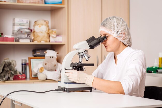 Science veterinarian working on microscope working woman research in lab medicine pet health care and people concept