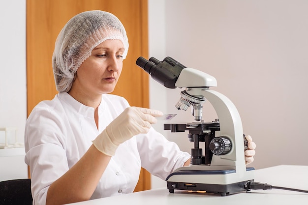 실험실 의학 애완 동물 건강 관리 및 사람 개념에서 현미경 작업 여성 연구에서 일하는 과학 수의사