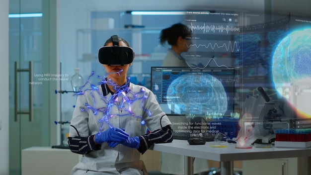 Scientific expert in laboratory wearing VR headset, using advanced equipment and wired sensors to visualize neurological synapses. Doctor using virtual reality technology to see medical info