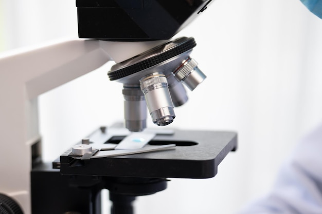 Научный микроскоп для использования в научной лаборатории, ученый-биолог, исследователь в области медицинских технологий, использующий оборудование для экспериментального образования в области химии или микробиологии и медицины.