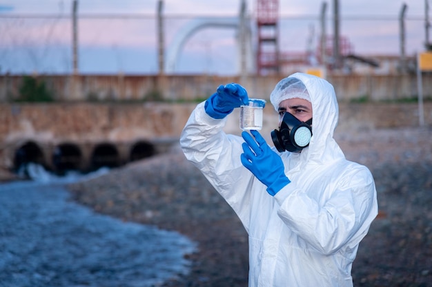 眼鏡と安全手袋をかぶった専門家による水質分析 - 廃水を検査するための研究室での環境汚染問題の概念