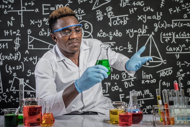 Ученый анализирует химические вещества, делая жесты на доске