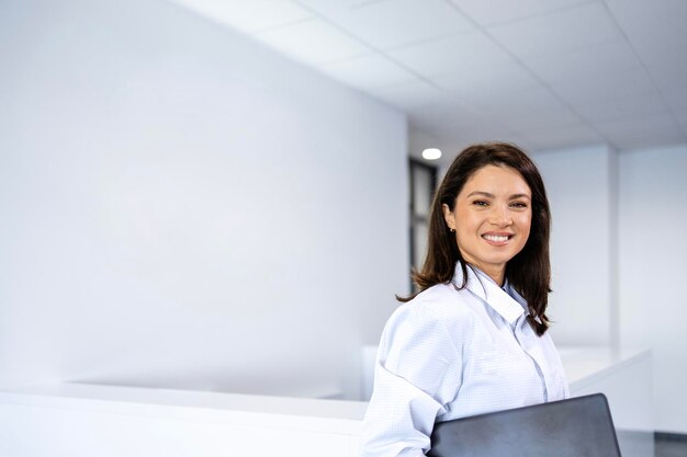 Photo scientist in antistatic protection suit standing in research laboratory and holding laptop computer