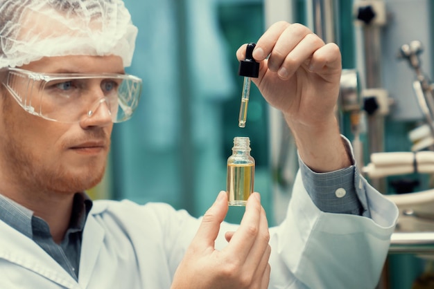 Photo scientist or apothecary extract cbd hemp oil for medicinal purpose in laboratory