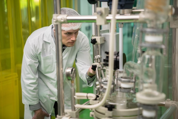 Estratto di farmacia scienziato utilizzando una macchina per l'estrazione di cannabis in laboratorio