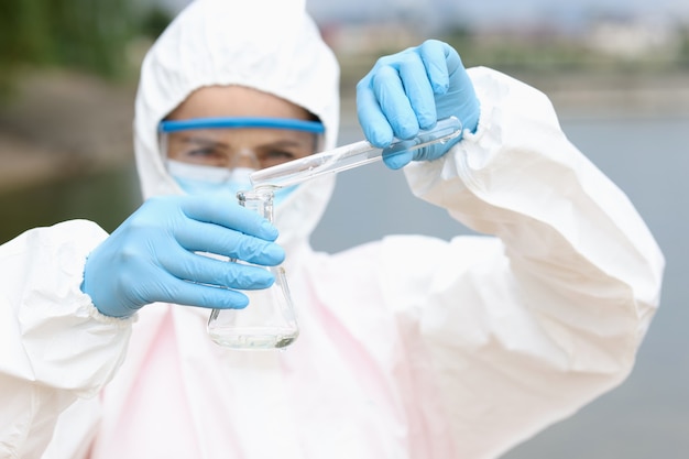 Scientist or biologist takes water sample near an industrial plant sample of water in chemical