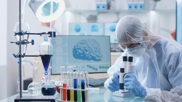 Scientist chemist analyzing blood sample using medical\
microscope during microbiology experiment in biochemistry hospital\
laboratory. researcher doctor developing vaccine against\
covid19