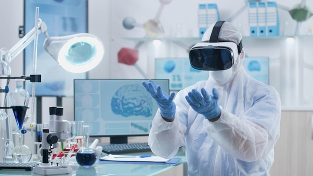 Scientist chemist doctor wearing virtual reality headset\
analyzing brain waves futuristic holografic interface during\
chemistry experiment in biochemistry hospital laboratory.\
neuroscience research