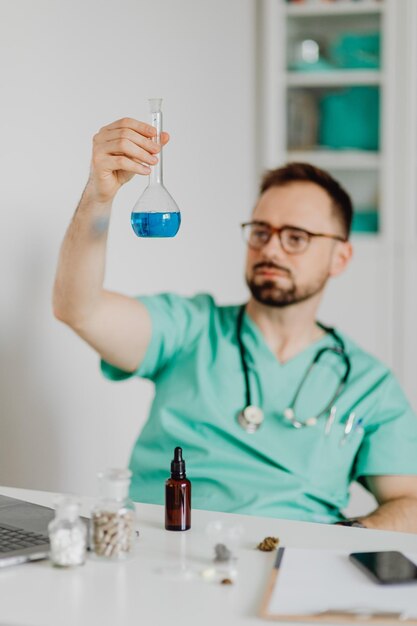 Scientist examining sample in beaker in laboratory