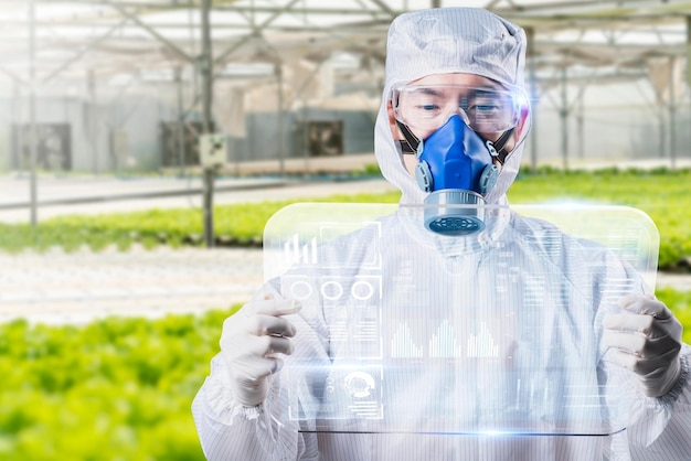 Scientist farmer growing plant in green house lab with IOT based smart agriculture monitoring system