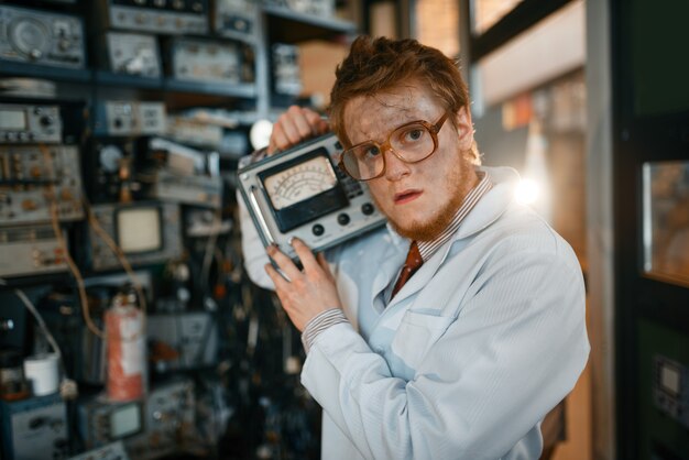 Scientist in glasses holds electrical device