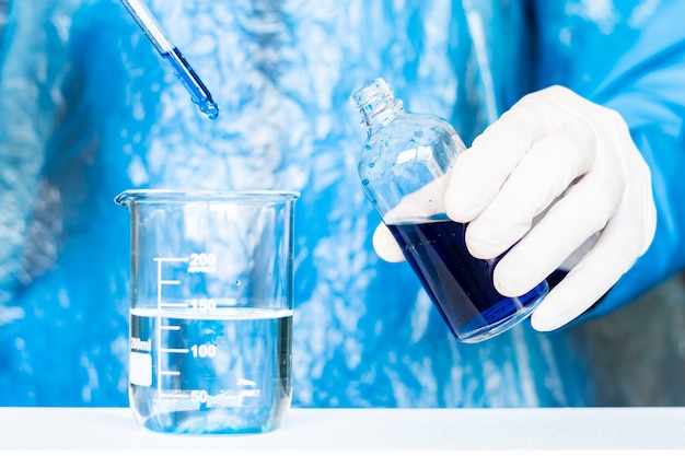 Photo scientist in gloves making experiment with reagents