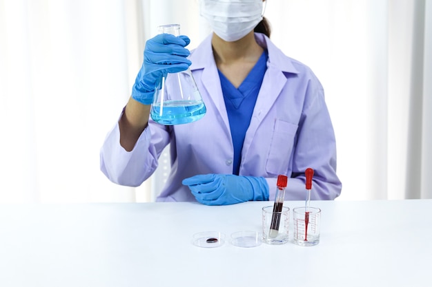 Scientist holding Coronavirus covid-19 infected blood sample tube DNA