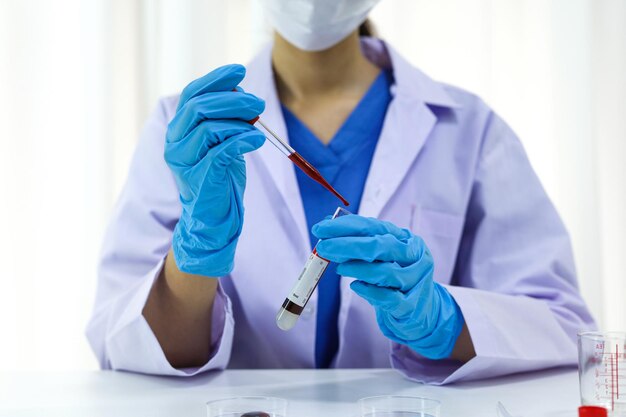 Scientist holding Coronavirus covid19 infected blood sample tube DNA testing of the blood in the laboratory with blood sample collection tubes and syringe Coronavirus Covid19 vaccine research