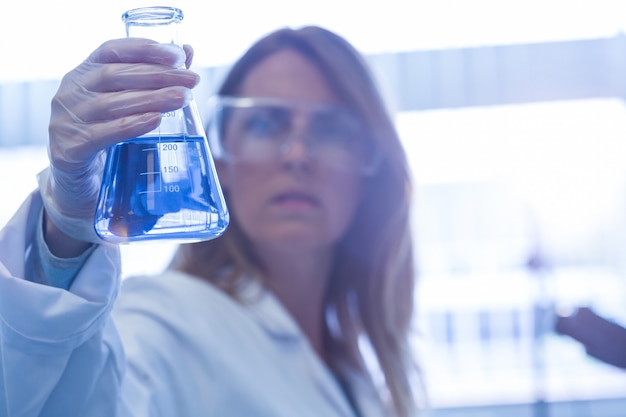 Scientist holding up beaker of chemical