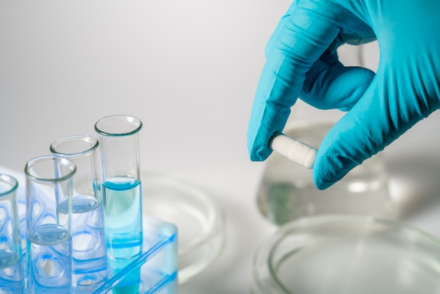 A scientist holds a white pill in a disposable glove. Concept - testing of new medicines, antibiotics, drugs