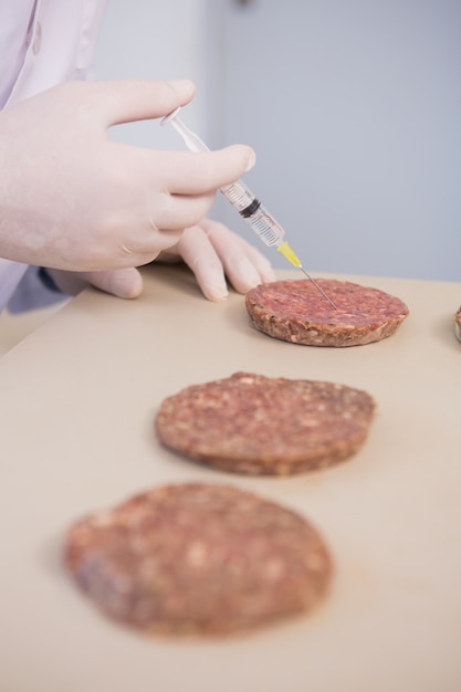 Scientist injecting beefsteaks 