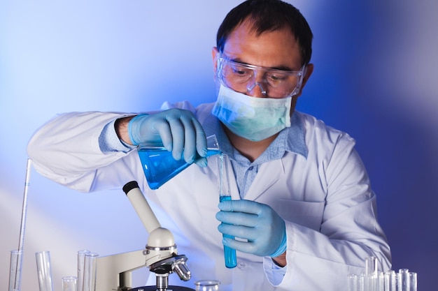 Foto lo scienziato sta facendo ricerche sul lavoro, l'uomo tiene la provetta con del liquido