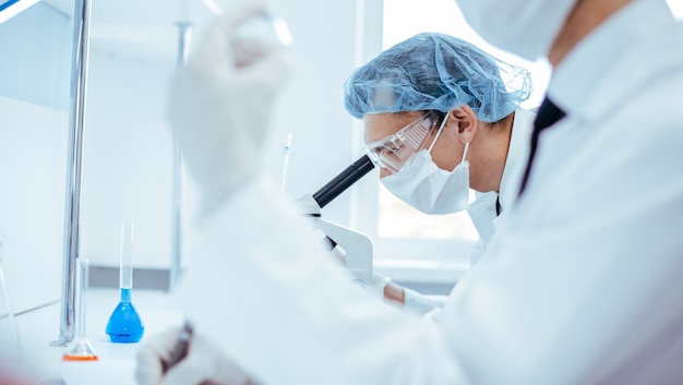 a scientist looking at a bottle of a new vaccine