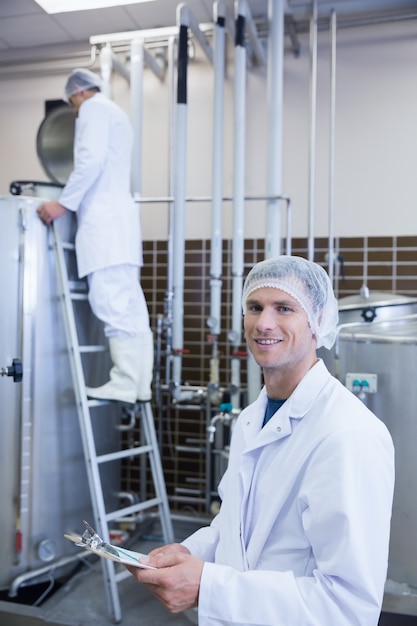 Scientist looking at camera with his colleague behind him