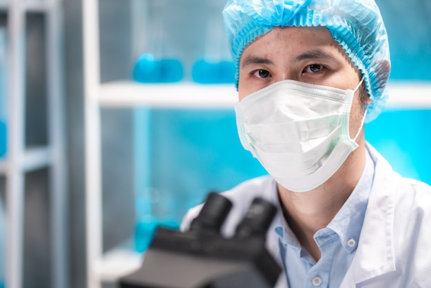 Scientist looking through scientific microscope lense in laboratory, scientist doing research in term of medicine biotechnology biology or chemistry, doctor analyzing work in medical microbiology lab