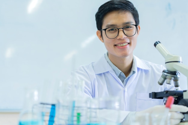 Scientist man with microscope on desk at laboratory room for\
research concept