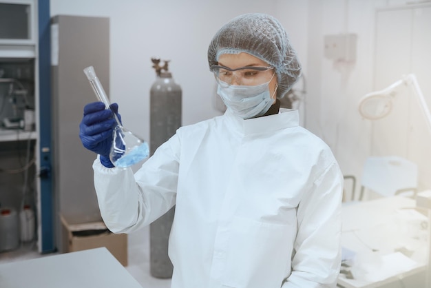 Photo scientist or medic holding a test tube blue liquid in laboratories for the study of biochemistry.