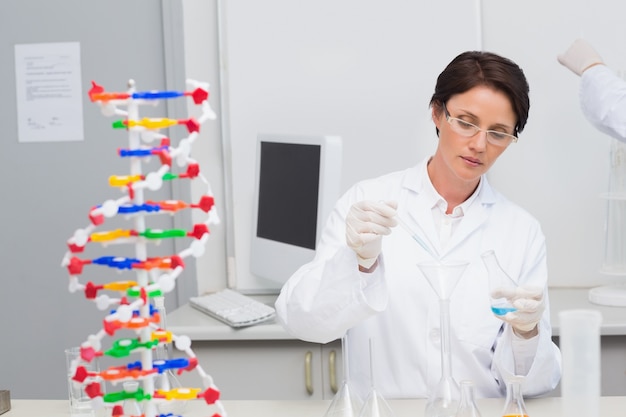 Scientist pouring chemical fluid in funnel