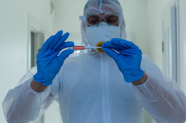 Scientist in protective gear with arms crossed in laboratory