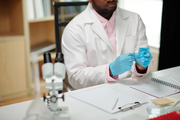 Scientist Putting on Blue Gloves