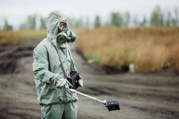 Scientist radiation supervisor in protective clothing and gas mask in the danger zone