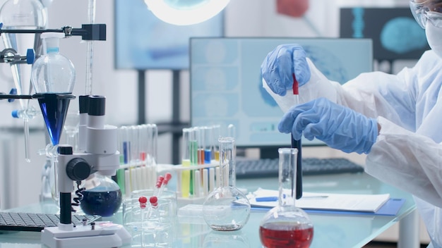 Scientist researcher working with medical test tube analyzing green liquid developing coronavirus vaccine during virus investigation in microbiology hospital laboratory. Scientific experiment