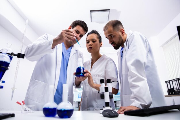 Photo scientist showing research to colleagues in laboratory