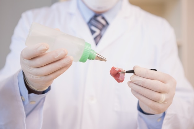 Scientist sprinkling fluid on meat 