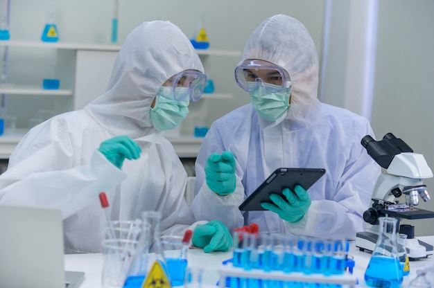 Il team di scienziati sta studiando la cura del coronavirus in laboratorio. medico asiatico che lavora al vaccino contro l'infezione da virus.