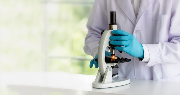 Photo scientist uses a microscope in the laboratory