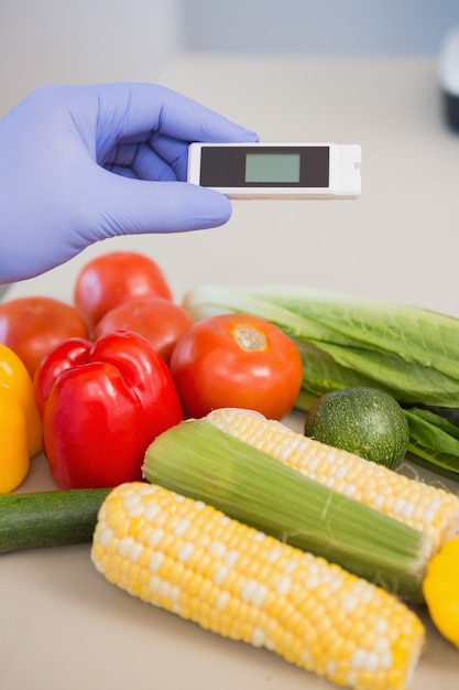 Photo scientist using device on vegetables