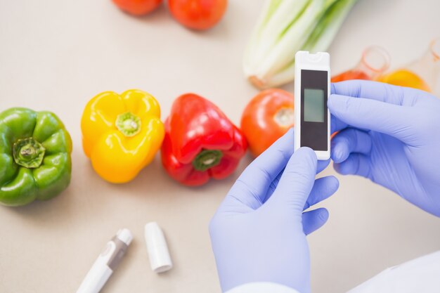 Photo scientist using device on vegetables