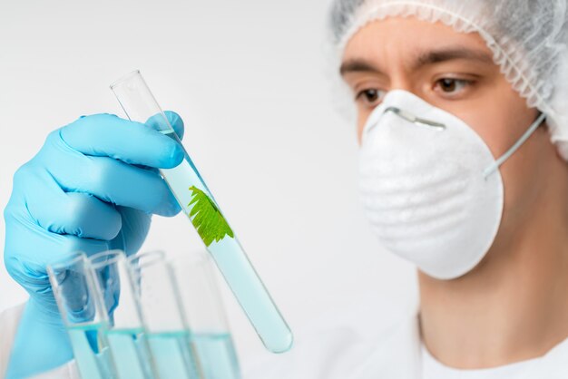 Scientist with brown eyes in protective wear with plant sample