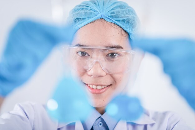 Scientist with equipment and science experiments ,laboratory glassware containing chemical liquid for design or decorate science or other your content and selective focus