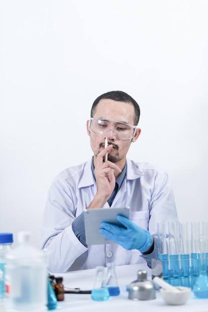 Scientist with equipment and science experiments, laboratory glassware containing chemical liquid for research or analyzing a sample into test tube in laboratory.