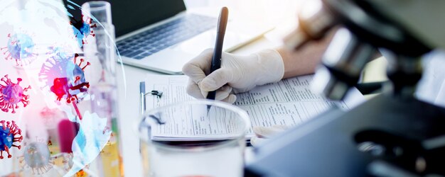 Scientist with protective gloves writing on paper