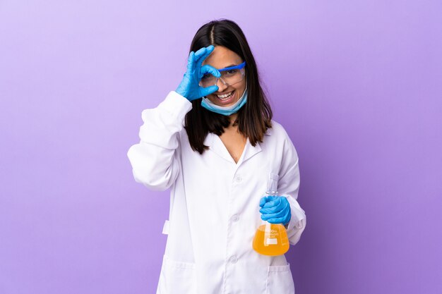 Scientist woman investigating a vaccine to cure disease showing ok sign with fingers