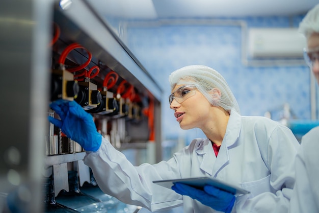 Photo scientist worker checking the quality of water bottles on the machine conveyor line at industrial