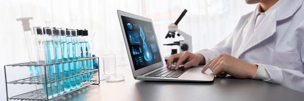 Photo scientist working on advance biotechnology computer software to study or analyze dna data after making scientific breakthrough from chemical experiment on medical laboratory neoteric